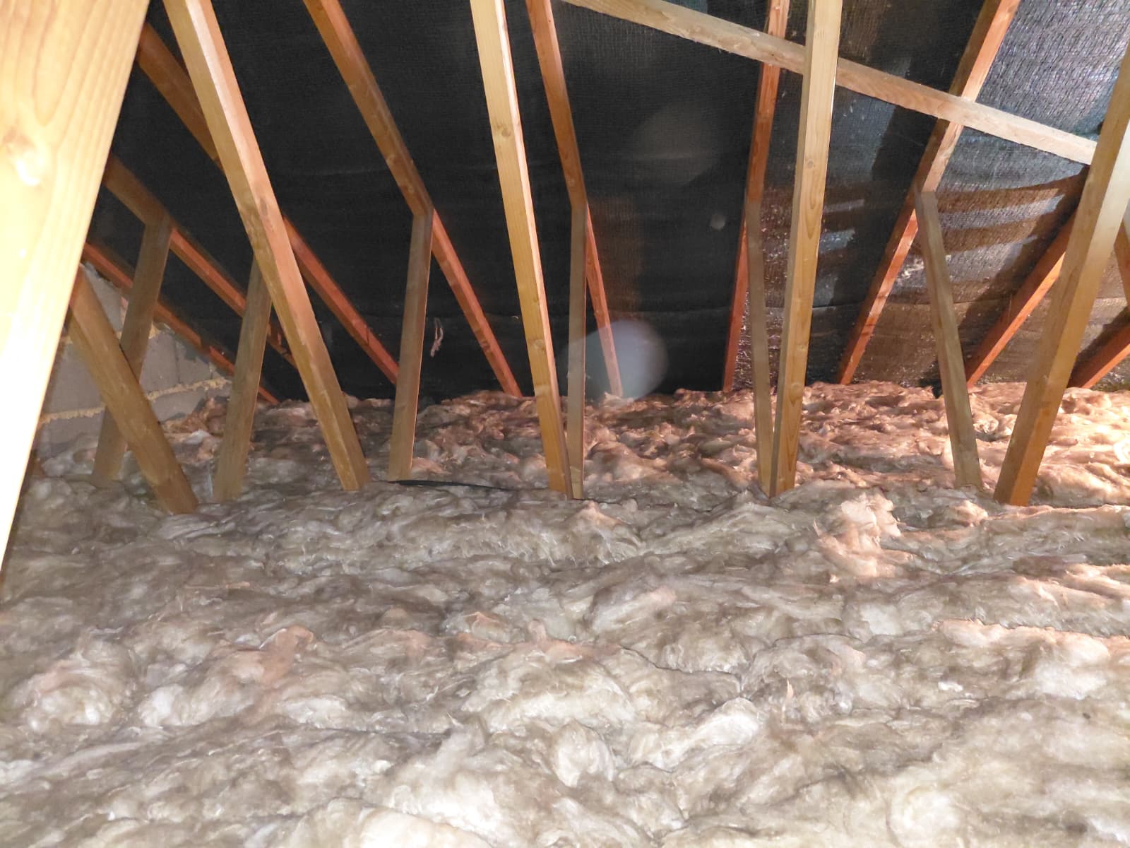 Thin mineral wool layer across loft floor with cold spots