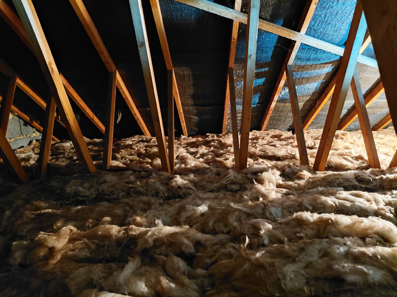 Patchy mineral wool between trussed rafters needing top up
